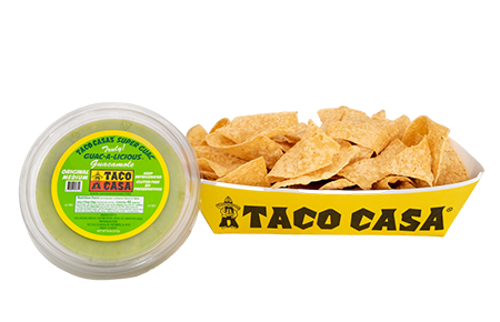 A bowl of tortilla chips and a container of taco casas.